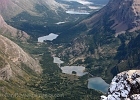 A wider view from the summit looking at a classic glacier-carved valley. From near to far is Bullhead, Redrock, Fishercap, and Swiftcurrent lakes.