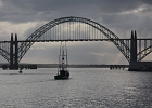 Commercial fishing boat heads out toward the Pacific under the Yaquina Bay Bridge. Newport, OR